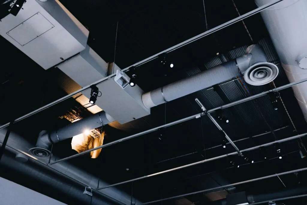 Sistema de ventilación eficiente en el techo de un local comercial de Málaga con conductos vistos y difusores.