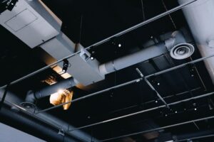 Sistema de ventilación eficiente en el techo de un local comercial de Málaga con conductos vistos y difusores.